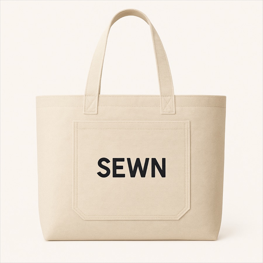 Tote in natural heavy canvas, mark centred on the lower third.